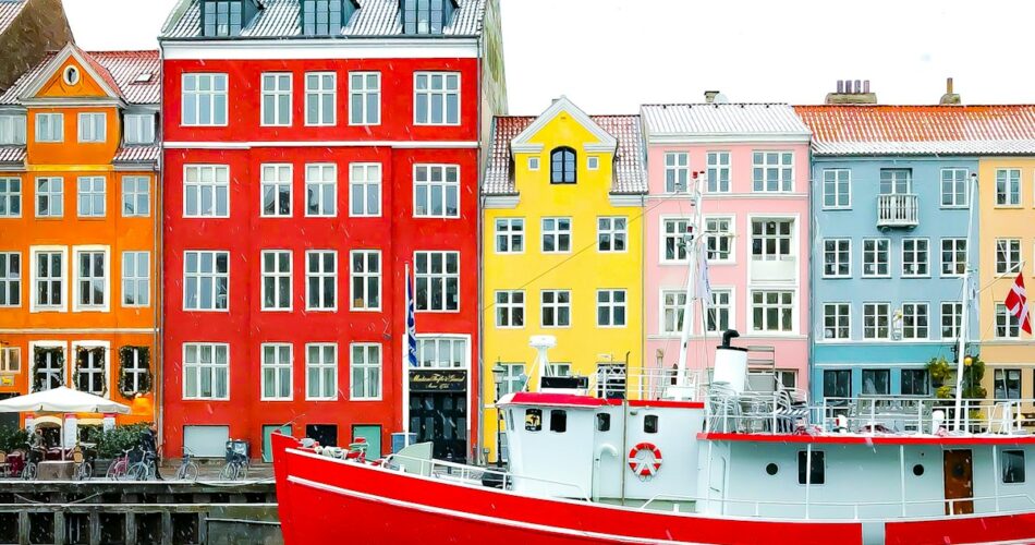 assorted-color buildings near red boat docked on port during daytime